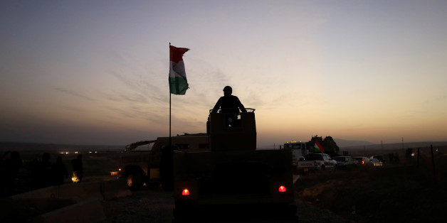 A Kurdish Peshmerga fighter looks over as he stands on the top of a humvee in front of an Islamic State militants' position outside the town of Naweran near Mosul, Iraq October 20, 2016. REUTERS/Zohra Bensemra TPX IMAGES OF THE DAY