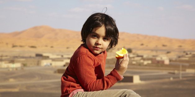Mixed race boy eating fruit