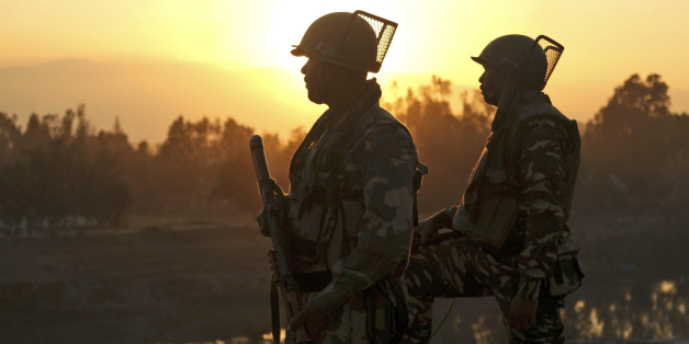 Indian soldiers stand guard near a building where suspected militants have taken refuge during a gun battle in Pampore, on the outskirts of Srinagar, Indian controlled Kashmir, Tuesday, Oct. 11, 2016. A handful of rebels holed up in a building in the Indian portion of Kashmir exchanged fire with government forces for the second straight day on Tuesday. (AP Photo/Mukhtar Khan)