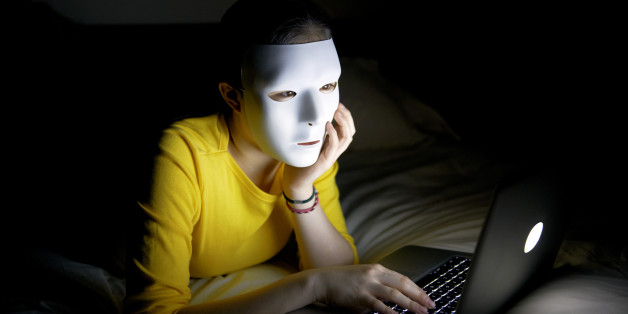 Anonymous teenager in mask on internet at night