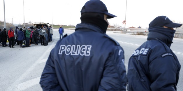 Refugees and migrants embark in a police van as policemen patrol on a highway near the northeastern Greek village of Thourio, at the Greek-Turkish border on Sunday, Jan. 24, 2016. The migrants told police they were part of a group of 130 who crossed the Evros river between Greece and Turkey overnight without the assistance of a trafficker. They spent the night cold and wet after crossing on foot. (AP Photo/Thanassis Stavrakis)