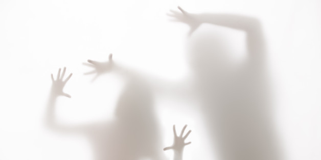Conceptual image of a young woman deputing horror, pain and suffering from abuse by a Man.