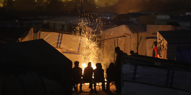 CALAIS, FRANCE - OCTOBER 24: Migrants sit by a fire inside the Jungle camp on October 24, 2016 in Calais, France. Many migrants have left by coach to be reloctated at centres across France as Police and officials in France begin to clear the 'Jungle' migrant camp in Calais. Some 7,000 people are estimated to be living in the camp in squalid conditions. (Photo by Christopher Furlong/Getty Images)