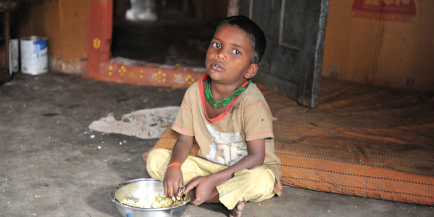 An Indian boy looks at the camera has he eats at his home in a slum in Hyderabad, on January 10, 2012. Levels of under-nutrition in the country were 'unacceptably high' despite impressive GDP growth, Prime Minister Manmohan Singh said Tuesday and added that the problem of malnutrition was a 'national shame'. AFP PHOTO / Noah SEELAM (Photo credit should read NOAH SEELAM/AFP/Getty Images)