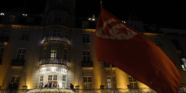 Well wishers hold a Tunisian flag as the Nobel Peace Prize 2015 winners, the members of the Tunisian National Dialogue Quartet appear on the balcony of the Grand Hotel in Oslo on December 10, 2015. The Nobel Peace Prize was awarded to four civil society groups, who led Tunisia's transition to democracy, though the country has now been plunged into a state of emergency as it battles the threat of jihadism. AFP PHOTO / ODD ANDERSEN / AFP / ODD ANDERSEN (Photo credit should read ODD ANDERSEN/AFP/Getty Images)