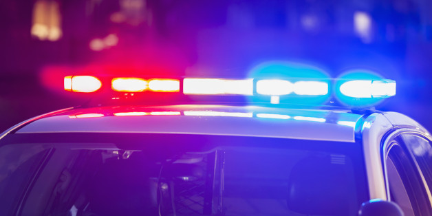 The roof of a police patrol car at night, with the blue and red lights flashing.