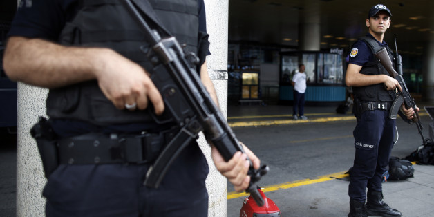 Police officers stand as family members, colleagues and friends of the victims of Tuesday blasts gather for a memorial ceremony at the Ataturk Airport in Istanbul, Thursday, June 30, 2016. A senior Turkish official on Thursday identified the Istanbul airport attackers as a Russian, Uzbek and Kyrgyz national hours after police carried out sweeping raids across the city looking for Islamic State suspects. Tuesday's gunfire and suicide bombing attack at Ataturk Airport killed dozens and injured ove