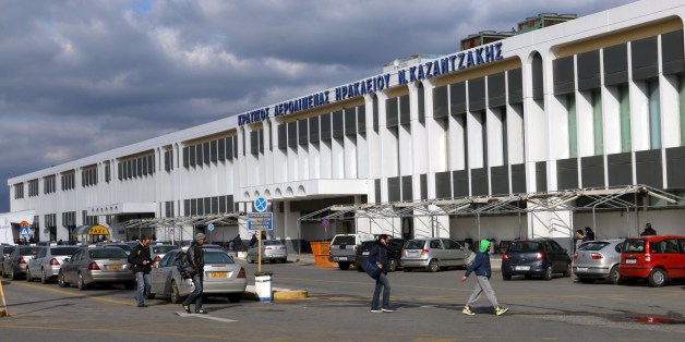 People walk past the state Heracleion airport 'Nikos Kazantzakis' in the city of Heracleion on the island of Crete, on February 21, 2015. Greece intends to review a 1.2 billion euro ($1.36 billion) deal with German airport operator Fraport to run 14 Greek airports, with a government minister saying the contract would be put on ice. The airports, put up for lease in 2014 to boost Athens' depleted cash reserves, include Thessaloniki, the second largest city in the country, and those of tourist hotspots. The new radical left government, which swept to power at the end of January and is currently embroiled in negotiations over its bailout obligations, had promised voters it would halt the privatisations. AFP PHOTO/ COSTAS METAXAKIS (Photo credit should read Costas Metaxakis/AFP/Getty Images)