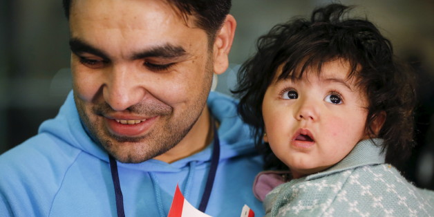 A Syrian refugee holds his daughter as they arrive at the Pearson Toronto International Airport in Mississauga, Ontario, December 18, 2015. REUTERS/Mark Blinch