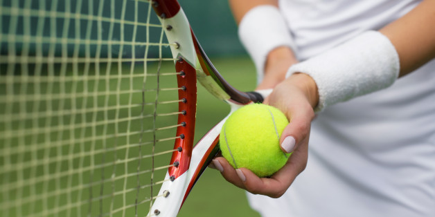 Close-up of tennis player holding racket and ball in hands