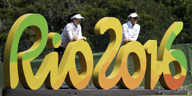 FILE - In this Aug.16, 2016 file photo, Kelly Tan, left, and Michelle Koh both of Malaysia, pose for a photo with the Rio 2016 logo on the 16th hole during a practice round for the women's golf event at the 2016 Summer Olympics in Rio de Janeiro, Brazil. The Rio Olympics could leave behind at least one unexpected legacy _ a new home for the consular office of the United States. The headquarters of the Rio de Janeiro Olympic organizing committee in central Rio will be abandoned in the next few w