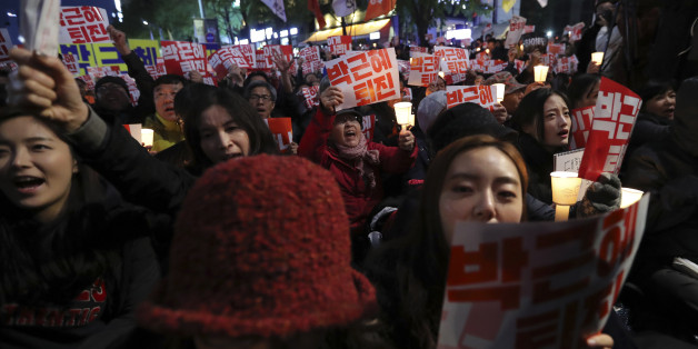 South Koreans shout slogans during an anti-president rally in downtown Seoul, South Korea, Saturday, Oct. 29, 2016. Thousands of South Koreans took to the streets of the capital on Saturday calling for increasingly unpopular President Park Geun-hye to step down over allegations that she let an old friend, the daughter of a religious cult leader, interfere in important state affairs. (AP Photo/Lee Jin-man)