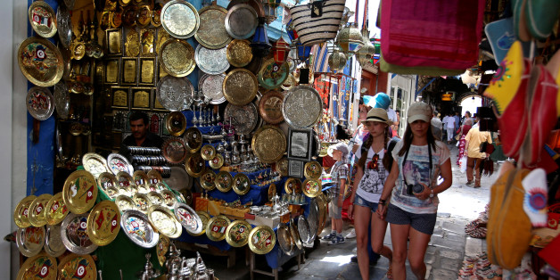 Tourists walk past traditional souvenirs displayed for sale in the old city of Tunis, Tunisia June 17, 2016. REUTERS/Zoubeir Souissi