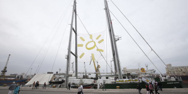 People walk past the Rainbow Warrior III, in the port of Casablanca, Morocco, Friday, Nov 4, 2016. Greenpeace's iconic ship is visiting Morocco ahead of the COP22 Climate Conference, to raise awareness about the massive potential for solar energy in the region.(AP Photo/Abdeljalil Bounhar)