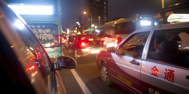 A taxi driver smokes a cigarette while waiting in traffic at night in the Luohu district of Shenzhen, China, on Monday, Aug. 4, 2014. China's consumer-price index (CPI) is scheduled to be released on Aug. 9. Photographer: Brent Lewin/Bloomberg via Getty Images