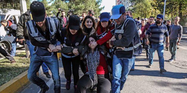 TOPSHOT - Turkish police officers detain Sabahat Tuncel (C), former Pro Kurdish People's Democracy Party (HDP) member of the Parliament on November 4, 2016 at Diyarbakir courthouse during a demonstration. The EU on November 4 warned Turkey to respect democratic norms when fighting Kurdish rebels and said it was 'gravely concerned' by the arrest of leaders of the country's main pro-Kurd party. / AFP / ILYAS AKENGIN (Photo credit should read ILYAS AKENGIN/AFP/Getty Images)