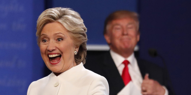 Democratic U.S. presidential nominee Hillary Clinton smiles at a member of the audience as she walks off the debate stage as Republican U.S. presidential nominee Donald Trump remains at his podium after the conclusion of their third and final 2016 presidential campaign debate at UNLV in Las Vegas, Nevada, U.S., October 19, 2016. REUTERS/Mike Blake
