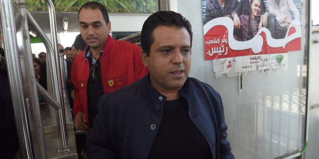 Tunisian presidential candidate and founder of the Free Patriotic Union Slim Riahi (C) arrives at a bus station during a campaign tour on November 19, 2014 in Tunis. Tunisia holds its first multi-candidate presidential election on November 23 in the final stage of a post-revolution transition that has set it apart from the turmoil of other Arab Spring states. AFP PHOTO/FETHI BELAID (Photo credit should read FETHI BELAID/AFP/Getty Images)