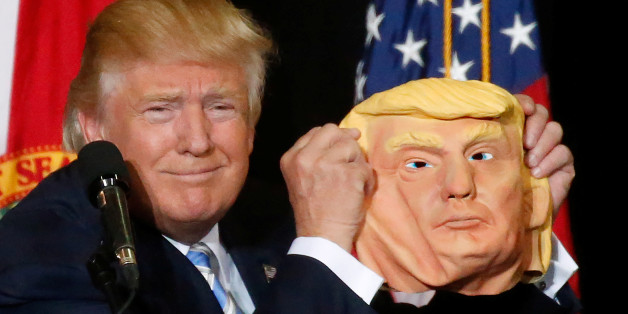 Republican presidential nominee Donald Trump holds up a mask of himself as he speaks during a campaign rally in Sarasota, Florida, U.S. November 7, 2016. REUTERS/Carlo Allegri
