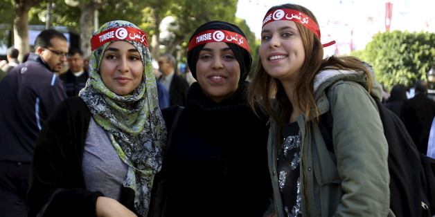 A Tunisian woman, who opposes the ruling moderate Islamic Ennahda Party, waves the national flag as she takes part in a rally in Tunis, Tunisia, Tuesday, Aug. 13, 2013. Supporters and opponents of Tunisia's Islamist-led government flooded the streets of the capital in rival rallies Tuesday marking national women's day. (AP Photo/Amine Landoulsi)