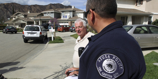 Resident Lorenzo Tatone (L) speaks to an Azusa police gang detective giving evacuation orders to residents in preparation against possible flash floods and mud slides in the second, and larger, of two storms to hit drought-plagued California this week in Azusa, California, February 27, 2014. The arrival of rain brings both minor relief from the third year of the worsening California drought and the threat of disastrous debris flows below mountainsides charred and hardened by an unseasonal wildfire, deemed the Colby Fire, that destroyed or damaged about two dozen homes, injured six people and sent thousands fleeing last month. Though welcomed, the rain is not expected to be enough to end the record historic conditions. REUTERS/David McNew (UNITED STATES - Tags: ENVIRONMENT)