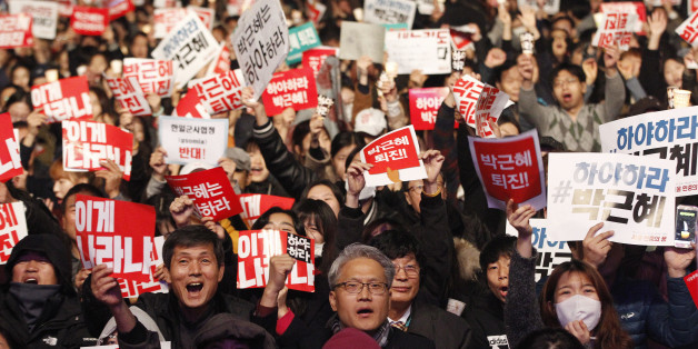 South Korean protesters shout slogans during a rally calling for South Korean President Park Geun-hye to step down in downtown Seoul, South Korea, Saturday, Nov. 5, 2016. Tens of thousands of South Koreans poured into the streets of downtown Seoul on Saturday, using words including "treason" and "criminal" to demand that Park step down amid an explosive political scandal. The signs read "Park Geun-hye should step down." (AP Photo/Ahn Young-joon)