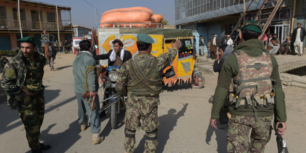 Afghan security personnel stop people as they block the road near the largest US military base in Bagram, 50 km north of Kabul, after an explosion on November 12, 2016. Four people were killed November 12 in an explosion inside the largest US military base in Afghanistan, NATO said, with local officials blaming a suicide attacker posing as a labourer for the major security breach. / AFP / SHAH MARAI (Photo credit should read SHAH MARAI/AFP/Getty Images)