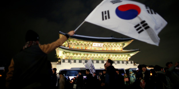 A man waves a national flag as people march toward the Presidential Blue House during a rally demanding President Park Geun-hye to step down in central Seoul, South Korea, November 12, 2016. REUTERS/Kim Hong-Ji