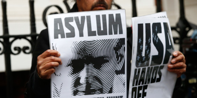 A supporter of Julian Assange holds posters after prosecutor Ingrid Isgren from Sweden arrived at Ecuador's embassy to interview him in London, Britain, November 14, 2016. REUTERS/Peter Nicholls
