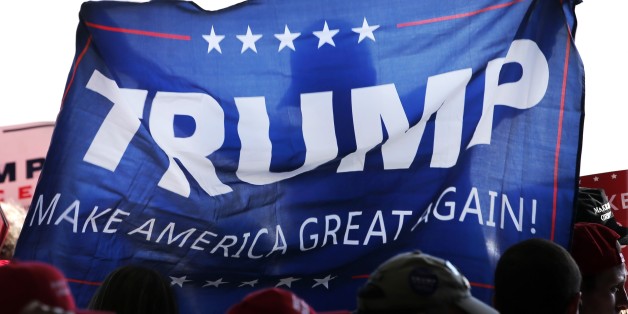 A supporter of Republican presidential candidate Donald Trump, holds up a campaign flag before Trump's arrival at a campaign stop at the Minneapolis International Airport Sunday, Nov. 6, 2016, in Minneapolis . (AP Photo/Charles Rex Arbogast)