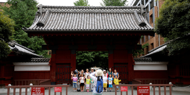 People pose for a photo in front of Akamon Gate at the University of Tokyo in Tokyo, Japan July 20, 2016. REUTERS/Toru Hanai AUNIV