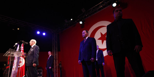 Beji Caid Essebsi, former Tunisian Prime Minister and leader of the Nida Touns (Call of Tunisia) secular party, speaks during a public meeting on the party's second anniversary of its founding, as bodyguards stand near him in Tunis January 27, 2013. REUTERS/Anis Mili (TUNISIA - Tags: POLITICS ANNIVERSARY)