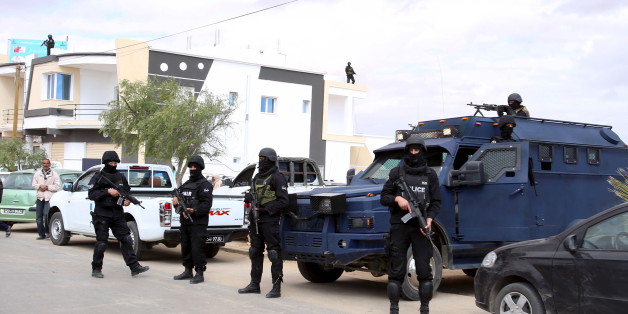 Tunisian police officers stand guard near a cemetery where soldiers and civilians who were killed during Monday's attack on army and police posts by Islamist fighters are buried in the town of Ben Guerdan, Tunisia, near the Libyan border March 9, 2016. REUTERS/Zoubeir Souissi