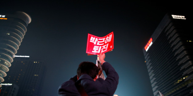 A man holds up a placard that reads "Call for Park Geun-hye to step down" during a rally calling on embattled President Park Geun-hye to resign over a growing influence-peddling scandal, in central Seoul, South Korea, November 5, 2016. REUTERS/Kim Hong-Ji