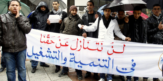 Unemployed graduates protest in front of the government office in Tunis January 30, 2012. Thirteen months after Tunisia's revolution, the economy continues to slump. Investment has slowed, tourism -- a mainstay of the economy -- is down, unemployment is rising and the government's target of 4.5 percent economic growth this year is looking over-optimistic.The banner reads:"We will not give up our right to development and operating". Picture taken January 30, 2012. To match Feature TUNISIA-ECONOMY/ REUTERS/Zoubeir Souissi (TUNISIA - Tags: EDUCATION BUSINESS EMPLOYMENT)