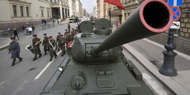 Russian army musicians walk past a World War II T-34 tank prior to a rehearsal for the Victory Day military parade which will take place at Dvortsovaya (Palace) Square on May 9 to celebrate 71 years after the victory in WWII, in St. Petersburg, Russia, Thursday, April 28, 2016. (AP Photo/Dmitri Lovetsky)
