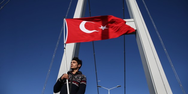 ISTANBUL, TURKEY - NOVEMBER 13: A man raises Turkish flag as Athletes and thousands of people take part in the 38th Vodafone Istanbul Marathon, the worlds only road race where people can run from Asia to Europe, at the July 15 Martyrs Bridge in Istanbul, Turkey on November 13, 2016. The 38th Vodafone Istanbul Marathons campaign for this year is: We are running for the July 15 martyrs. The races started on the Asian side of the July 15 Martyrs Bridge, formerly known as the Bosphorus Bridge, and w