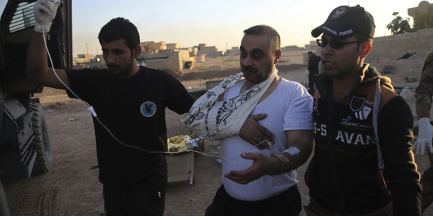 Iraqi special forces soldiers from the medical unit, help a civilian man who get injured by a mortar shell, at a field hospital at al-Samah neighborhood, in Mosul, Iraq, Saturday, Nov. 19, 2016. Iraqi troops faced stiff resistance Saturday from Islamic State militants as they pushed deeper into eastern Mosul, backed by aerial support from the U.S.-led international coalition, a senior military commander said. (AP Photo/Hussein Malla)