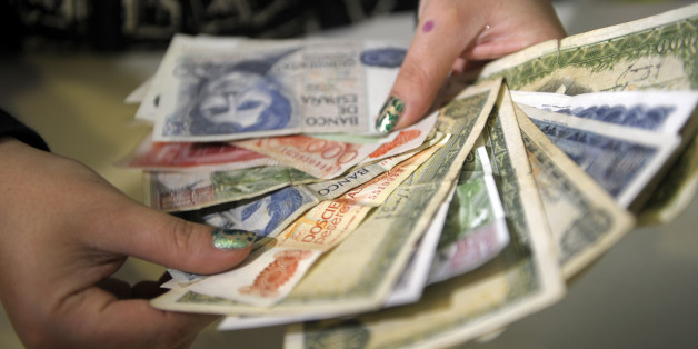 TO GO WITH AFP STORY BY Katell ABIVEN 'Espagne-dette-finance-économie-UE-euro'
A sales clerk shows pesetas notes collected at her store in Salvaterra de Mino, northwestern Spain, on December 15, 2011. In Salvaterra, on the border between Spain and Portugal, restaurants, taxi drivers, pharmacies and about 50 other businesses have been accepting payments in the old Spanish currency for one month. AFP PHOTO / MIGUEL RIOPA (Photo credit should read MIGUEL RIOPA/AFP/Getty Images)