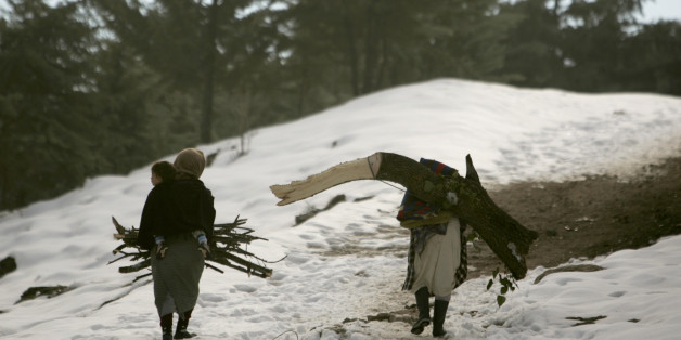 Women carry firewood through a forest in the snow-covered Middle Atlas region of Morocco near Ifrane January 10, 2008. REUTERS/Rafael Marchante (MOROCCO)
