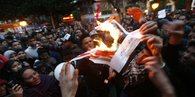 Tunisians celebrate the first year anniversary of the revolution as they burn pictures of Tunisia's ousted president Zine al-Abidine Ben Ali at Bourguiba Avenue in Tunis January 14, 2012. Tunisians on Saturday marked the first anniversary of the revolution that started the "Arab Spring" with celebrations that were true to the spirit of the revolt: raucous, unscripted, and driven by the energy of ordinary people. Thousands of people flooded into Bourguiba Avenue in the centre of the capital, the same spot where demonstrators massed exactly one year ago, forcing autocratic leader Zine al-Abidine Ben Ali to accept his rule was over and flee the country. REUTERS/Anis Mili (TUNISIAANNIVERSARY - Tags: POLITICS CIVIL UNREST)