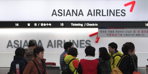Passengers wait to buy tickets at the Asiana Airlines ticketing counter at Gimpo airport in Seoul, South Korea, Friday, Nov. 8, 2013. Asiana Airlines Inc. reported its first profitable quarter this year as travel peaked during the fall holidays.(AP Photo/Ahn Young-joon)