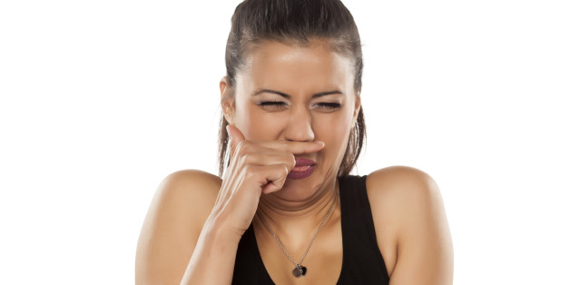 beautiful young dark skinned woman is disgusted by the smell