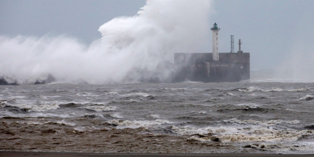 Waves crash against a lighthouse as the wind blows at around 120 kph (75mph), in Boulogne-sur-Mer, northern France, November 20, 2016. REUTERS/Pascal Rossignol