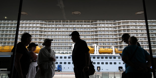 Tourists enter a passenger terminal, after their arrival with the "Ovation of the Seas" cruise ship at the port of Piraeus, near Athens, on Sunday, May 15, 2016. Greece expects a significant increase in the number of tourists who will be visiting the country in 2016, according to the Greek Ministry of Tourism. (AP Photo/Yorgos Karahalis)