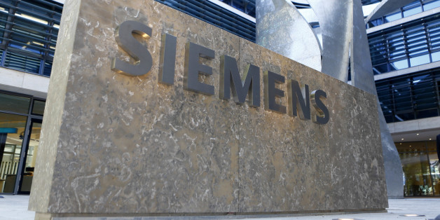 FILE - In this June 24, 2016 file picture the logo of German industrial conglomerate Siemens is pictured prior to opening ceremony at the new headquarters in Munich, Germany. German industrial equipment maker Siemens AG says it has agreed to buy U.S.-based software firm Mentor Graphics Corp. for US $4.5 billion. The companies said in a joint statement Monday Nov. 14, 2016 that Mentor's board recommended shareholders approve the deal. (AP Photo/Matthias Schrader,file)