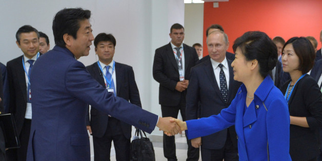 Japanese Prime Minister Shinzo Abe (L) shakes hands with South Korean President Park Geun-hye as Russian President Vladimir Putin stands in the background during the Eastern Economic Forum in Vladivostok, Russia, September 3, 2016. Sputnik/Kremlin/Alexei Druzhinin/via REUTERS ATTENTION EDITORS - THIS IMAGE WAS PROVIDED BY A THIRD PARTY. EDITORIAL USE ONLY.