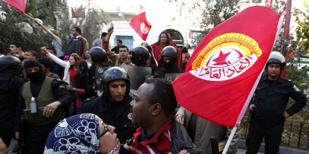 A member of main labour union body UGTT is held back during a clash between main labour union body UGTT and Islamists, at a gathering where they called for a general strike and downfall of the government led by the Islamist Ennahda party in Tunis December 4, 2012. Tunisian police broke up a clash in Tunis on Tuesday after pro-government Islamists attacked labour union leaders they blamed for inciting protests last week against the Islamist government. Several hundred Islamists with knives and sticks charged a gathering of the UGTT main labour union body in the capital and broke its office windows with stones, a Reuters witness said. Police then intervened to separate the two groups. REUTERS/Anis Mili (TUNISIA - Tags: BUSINESS CIVIL UNREST POLITICS EMPLOYMENT)