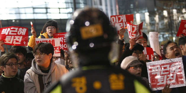 South Korean protesters march toward the presidential house during a rally calling for South Korean President Park Geun-hye to step down in Seoul, South Korea, Saturday, Nov. 19, 2016. For the fourth straight weekend, masses of South Koreans were expected to descend on major avenues in downtown Seoul demanding an end to the presidency of Park, who prosecutors plan to question soon over an explosive political scandal. The banners read: "Park Geun-hye should step down". (AP Photo/Ahn Young-joon)