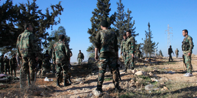 Syrian government forces inspect an area near the village of Khan Tuman, south from the provincial capital Aleppo, on December 22, 2015, two days after army units and other pro-regime forces recaptured several areas in the north of the country from Islamist forces, including Al-Qaeda's Syrian branch, Al-Nusra Front and Ahrar al-Sham brigade. Khan Tuman was the scene of fierce clashes between loyalist forces, including fighters of Lebanon's Shiite militia Hezbollah, and Islamist rebels, said the